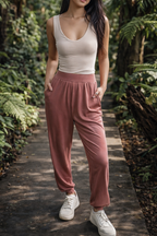 Woman in beige crop top with joggers in garden background
