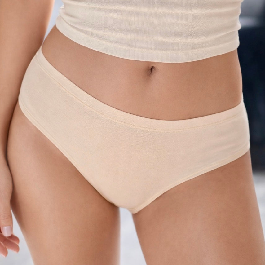 Beige bamboo underwear worn by a person on a blurred background